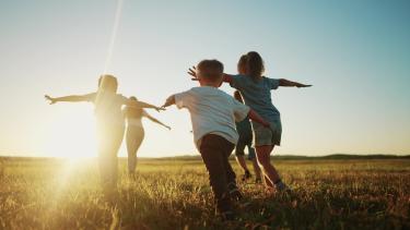 Illustrasjonsbilde av barn som løper på en åker. Foto: Adobe Stock/maxximmm